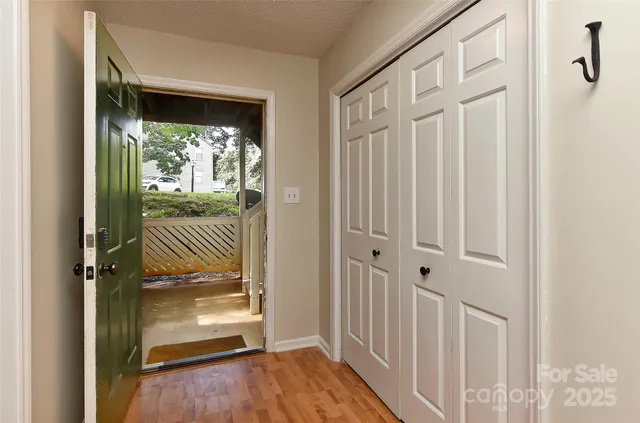 a view of a hallway with a door and wooden floor