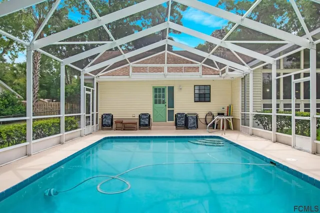 a view of a swimming pool with a patio and a yard