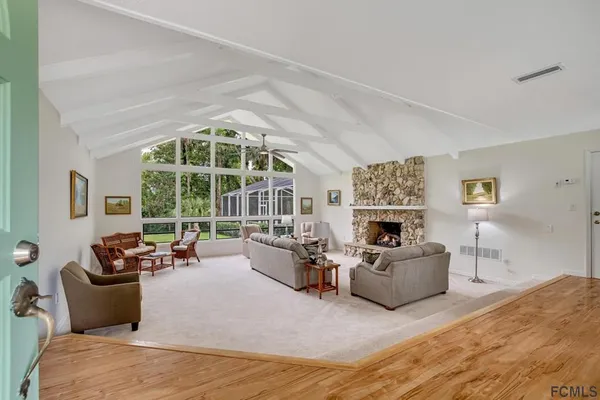 a living room with furniture large window and flat screen tv