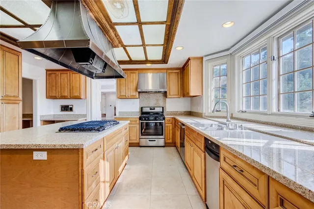a view of an empty room with a fireplace and chandelier fan