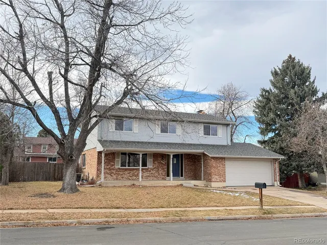 a front view of a house with a tree