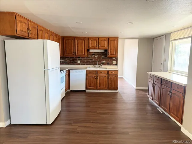 a kitchen with stainless steel appliances granite countertop a refrigerator a stove a sink and a microwave