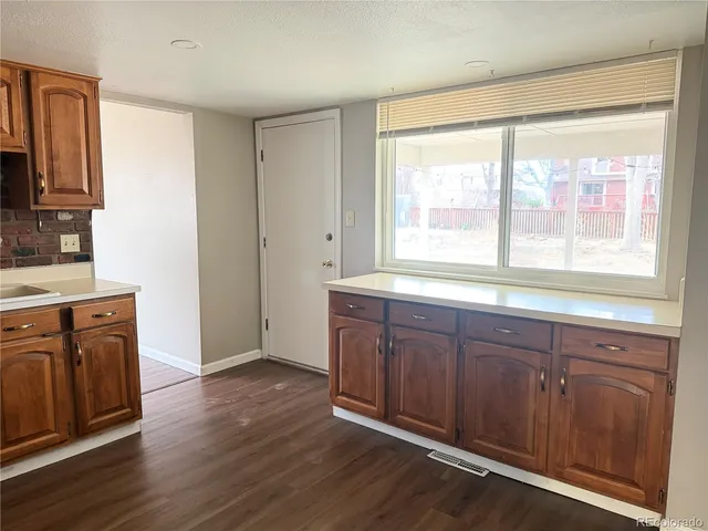a view of a kitchen counter space with wooden floor and electronic appliances