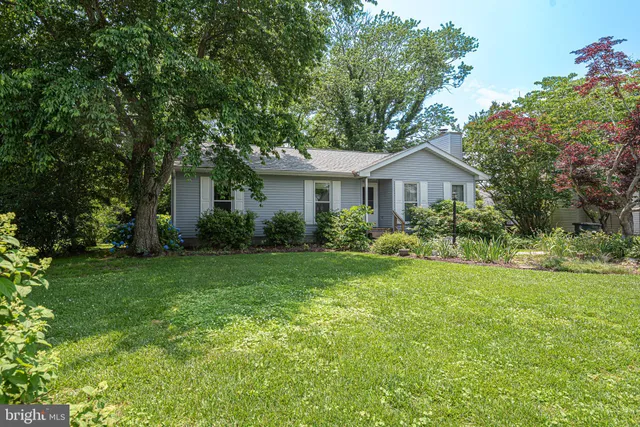 a front view of a house with a yard and trees