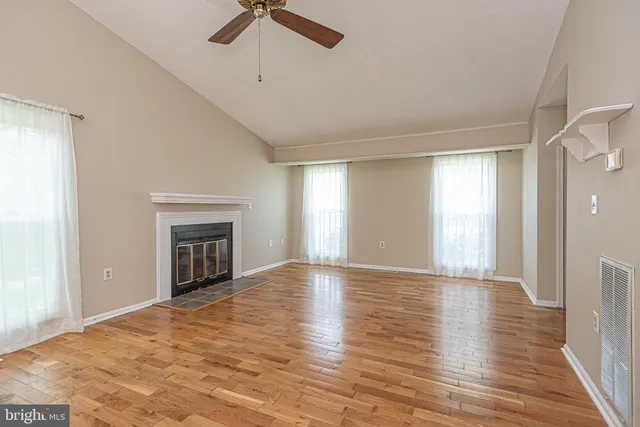 a view of an empty room with a window and fireplace