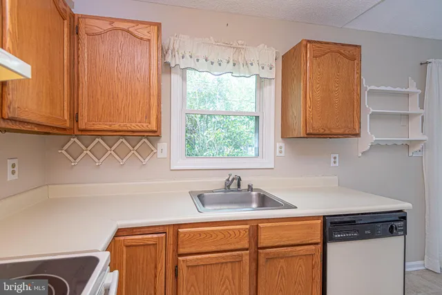 a kitchen with stainless steel appliances granite countertop a sink and a window