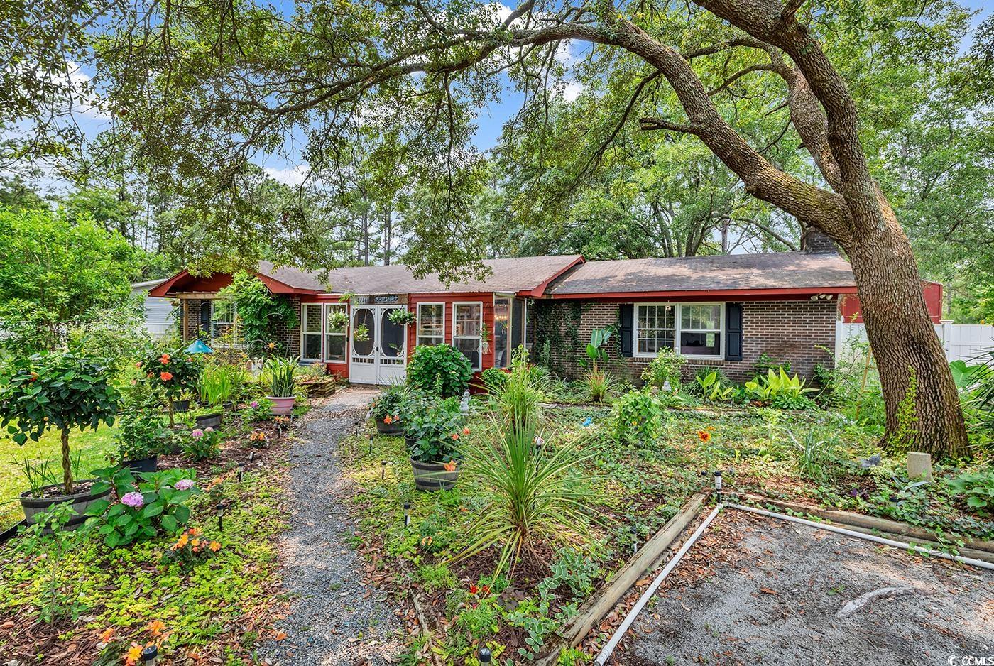 Ranch-style home with brick siding, a garden, and