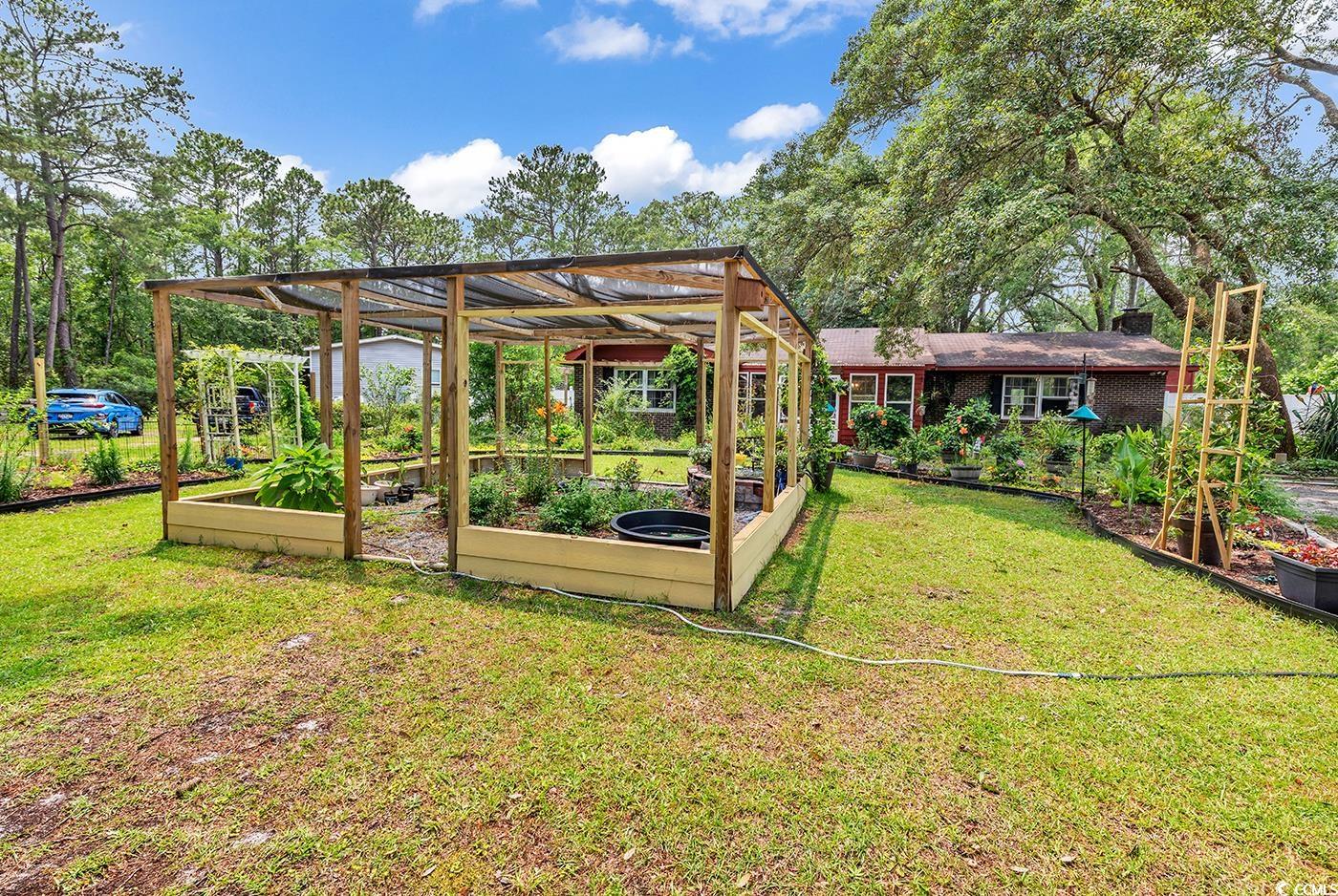 5114 Cowart Court Murrells Inlet, SC 29576 - Photo 33 of 38 View of green lawn with a vegetable garden
