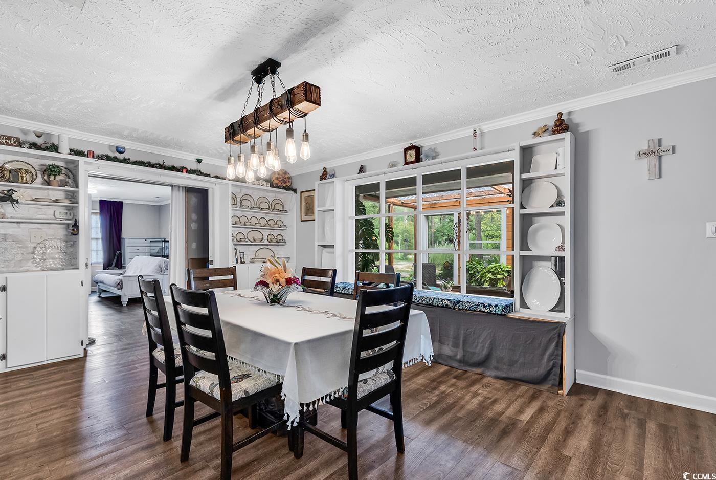 Dining room with ornamental molding, a textured ce