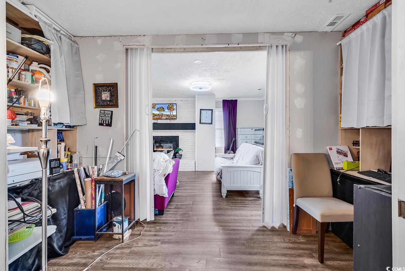 Hall featuring wood finished floors and a textured