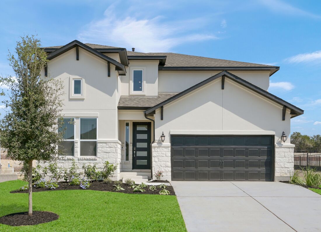 a front view of a house with a yard and trees