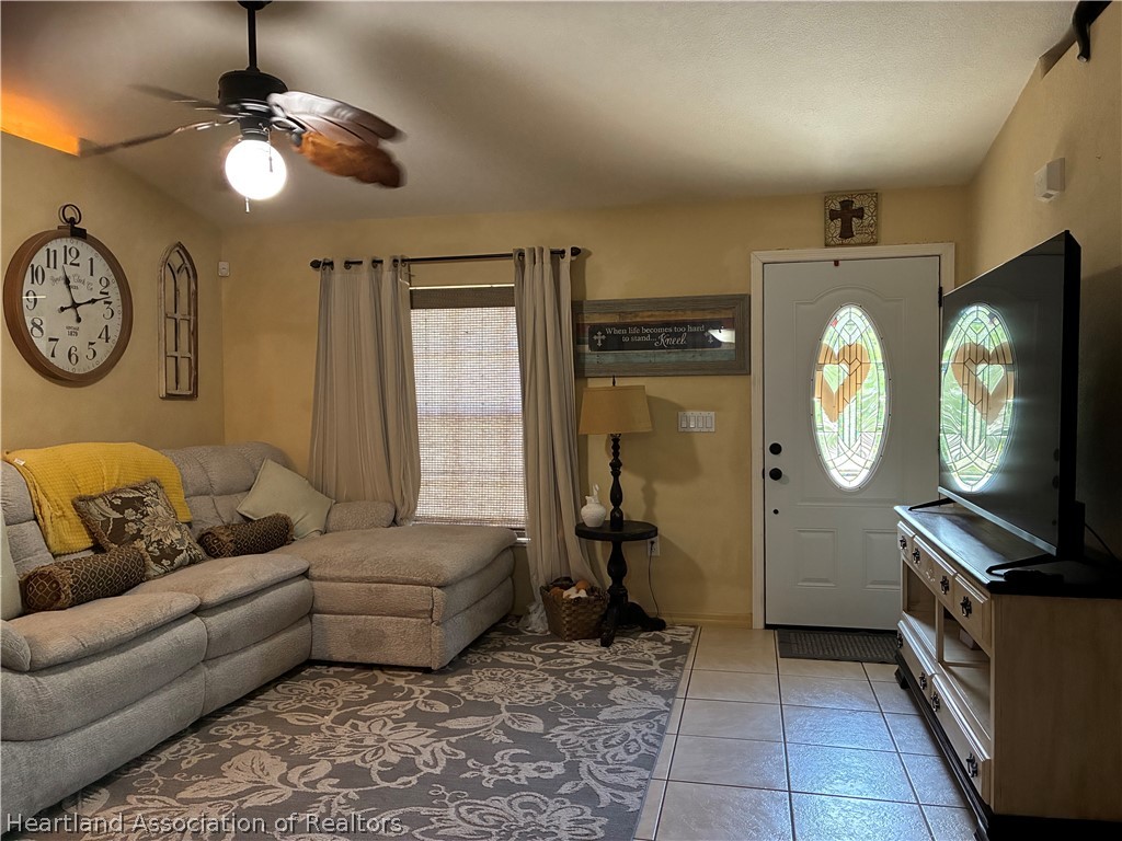 922 Breezy Road Lake Placid, FL 33852 - Photo 5 of 18 a living room with furniture a clock and a flat screen tv