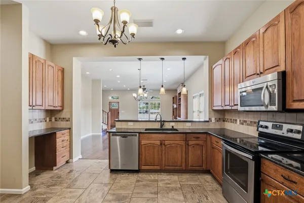a kitchen with stainless steel appliances a stove sink and cabinets