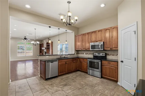 a kitchen with stainless steel appliances granite countertop a sink and stove top oven