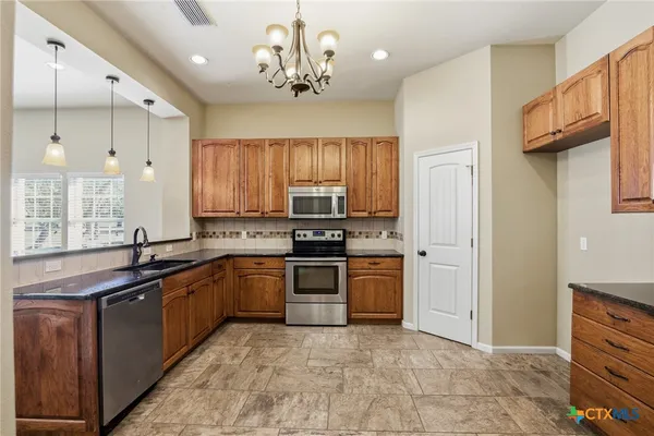 a kitchen with stainless steel appliances granite countertop a sink and cabinets