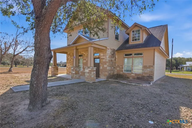 a view of a house with a tree in front