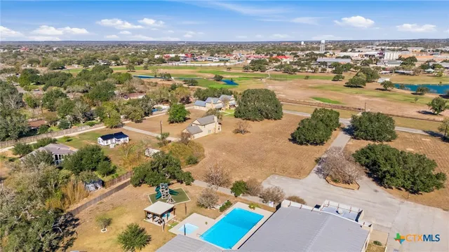 an aerial view of a house with a yard and large trees
