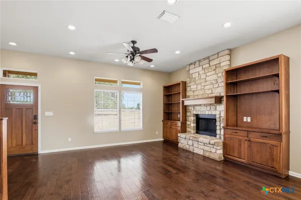 a view of an empty room with a fireplace and a window