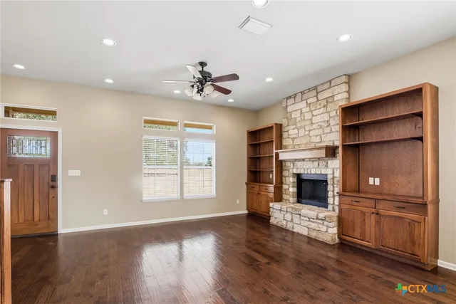 a view of an empty room with a fireplace and a window