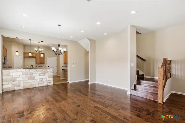 a view of an empty room and kitchen view