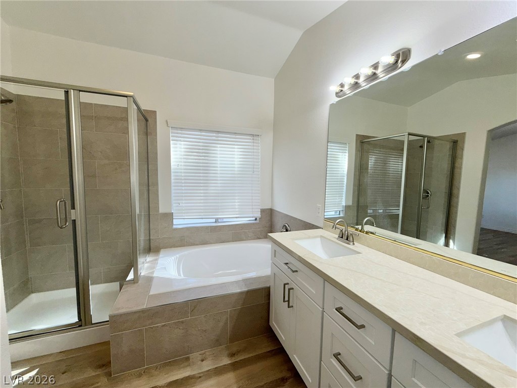 9729 Trail Rider Drive Las Vegas, NV 89117 - Photo 16 of 26 A well-appointed primary bathroom featuring a spacious dual vanity, a soaking tub, and a glass-enclosed shower.