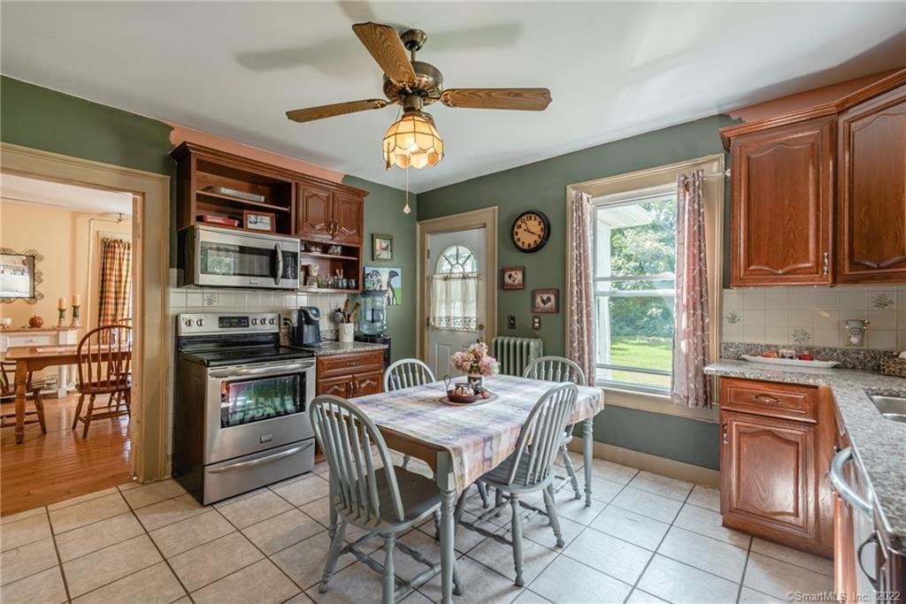 677 Kent Road New Milford, CT 06755 - Photo 1 of 1 a kitchen with stainless steel appliances granite countertop a stove top oven a sink dishwasher a dining table and chairs with wooden floor