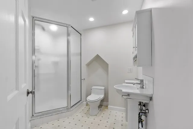 a bathroom with a sink a toilet and shower