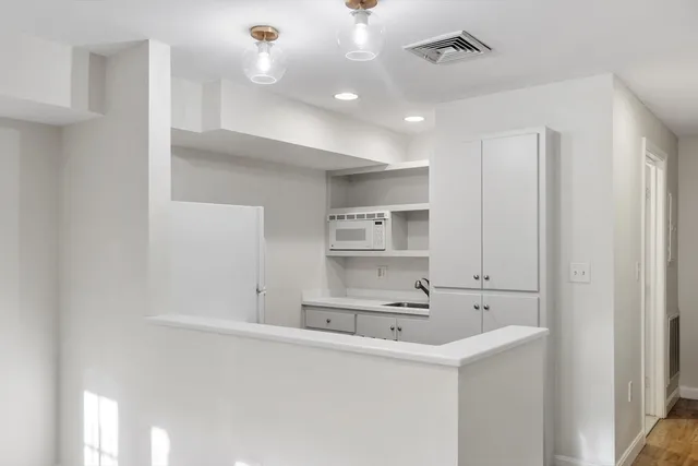 a kitchen with kitchen island a sink stainless steel appliances and cabinets