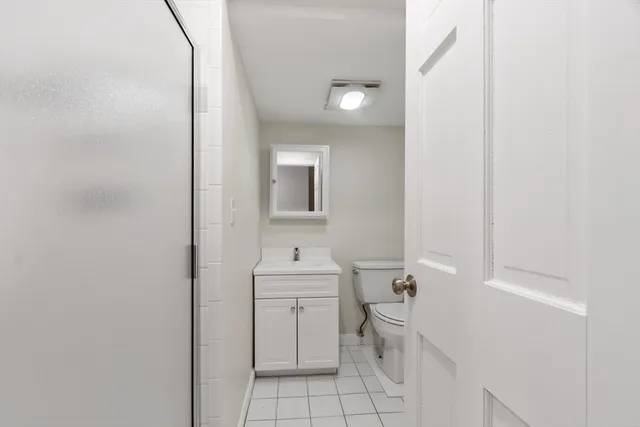 a bathroom with a toilet sink vanity and mirror