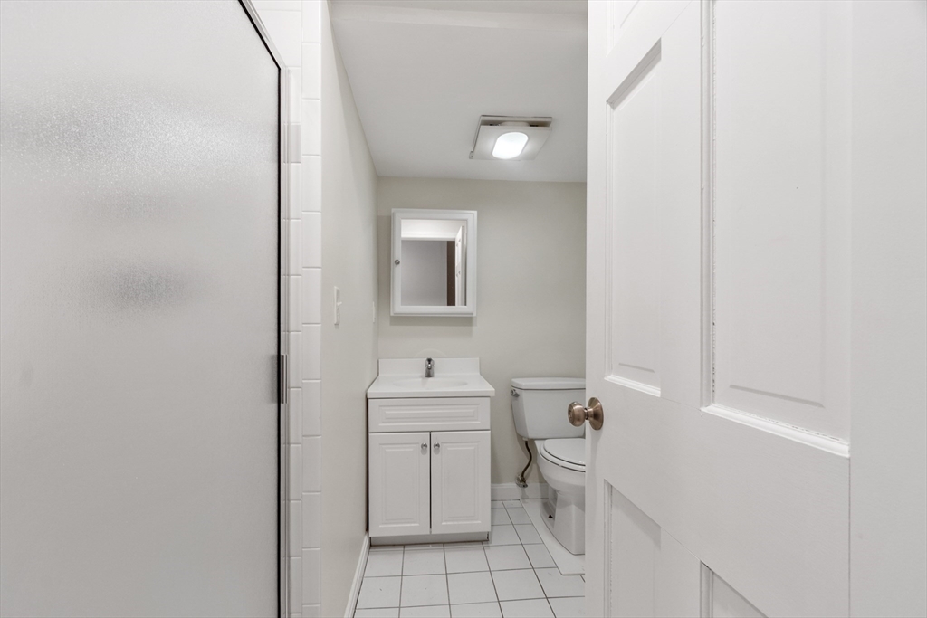 27 R West Street, Unit 8 Beverly, MA 01915 - Photo 6 of 21 a bathroom with a toilet sink vanity and mirror