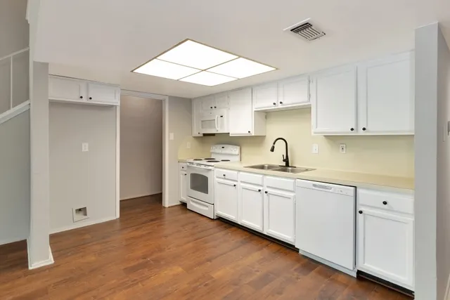 a kitchen with granite countertop a sink stainless steel appliances and cabinets