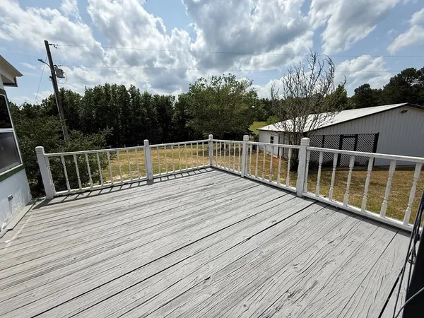a view of balcony with wooden floor and fence