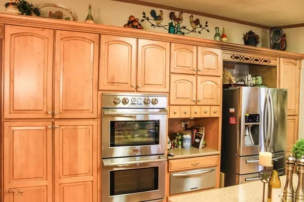 a kitchen with stainless steel appliances granite countertop a refrigerator and cabinets