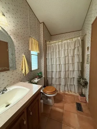 a bathroom with a sink a toilet and shower curtain