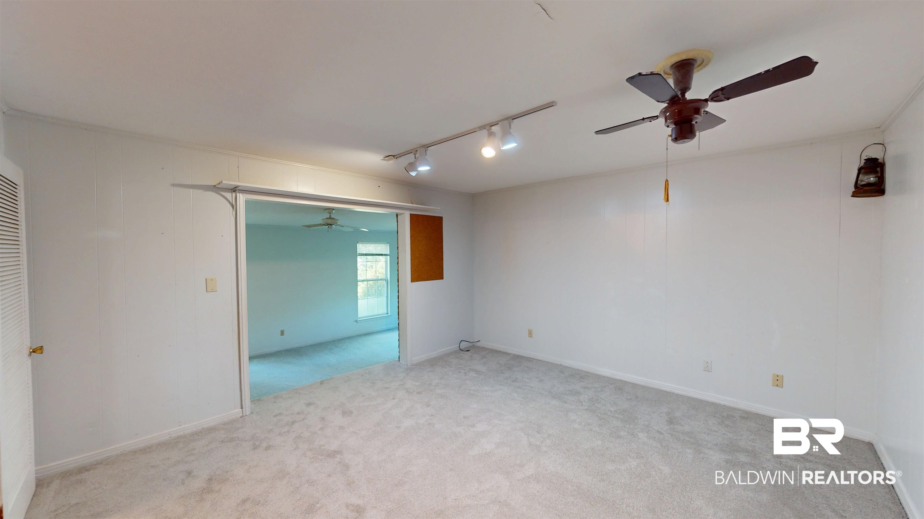 1075 Zurich Street Mobile, AL 36608 - Photo 18 of 35 Empty room with track lighting, a ceiling fan, and light carpet