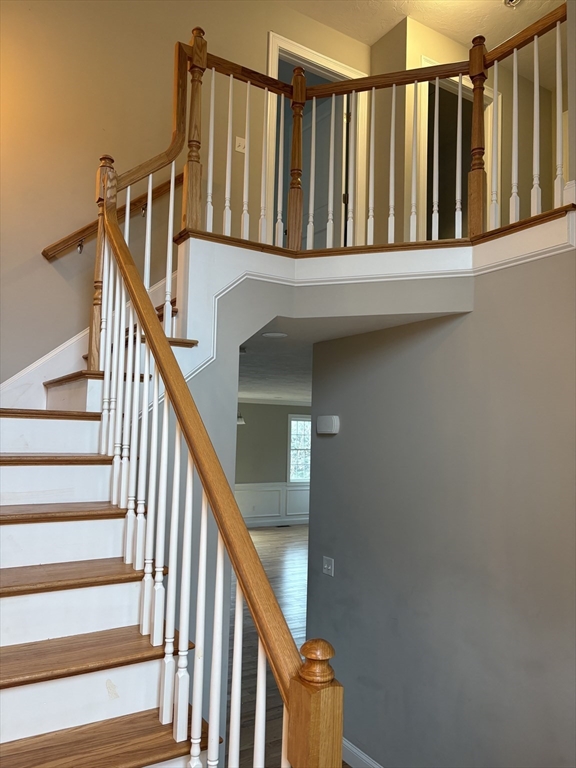 168 Main Street, Unit 1 Boylston, MA 01505 - Photo 11 of 24 a view of staircase with railing and white walls