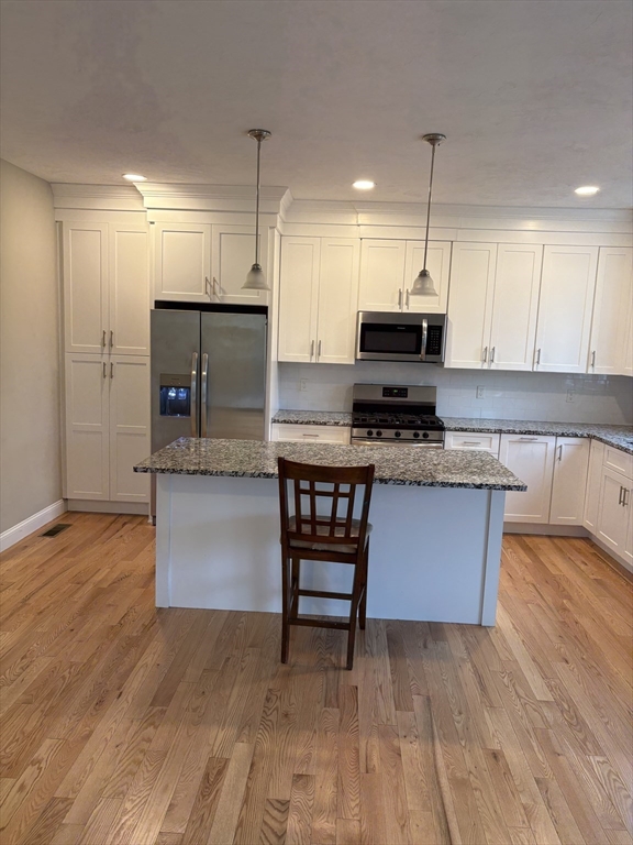 168 Main Street, Unit 1 Boylston, MA 01505 - Photo 4 of 24 a kitchen with stainless steel appliances granite countertop a stove a refrigerator and a wooden floors