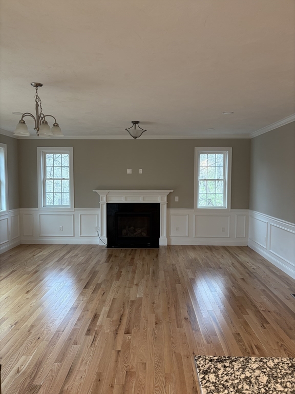 168 Main Street, Unit 1 Boylston, MA 01505 - Photo 6 of 24 an empty room with wooden floor fireplace and windows