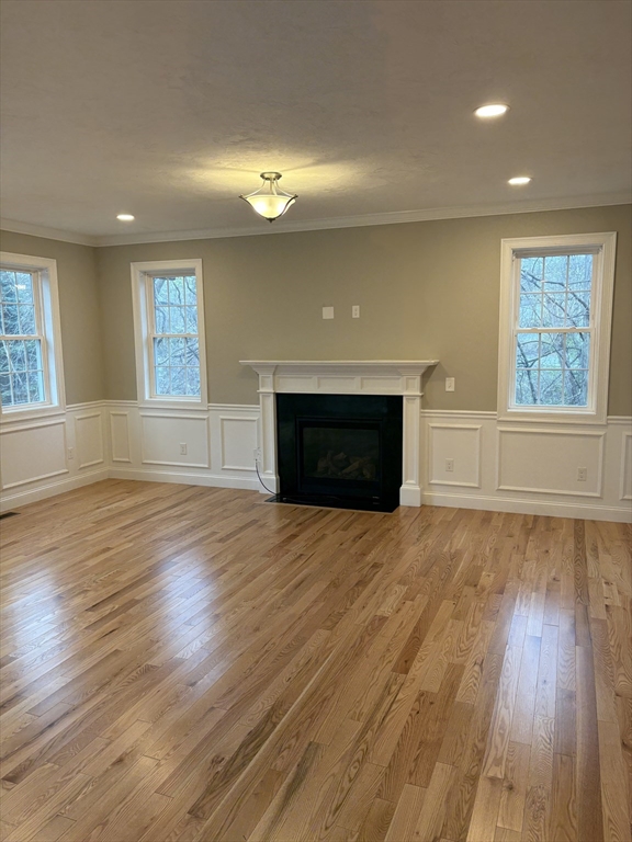 168 Main Street, Unit 1 Boylston, MA 01505 - Photo 8 of 24 an empty room with wooden floor fireplace and windows