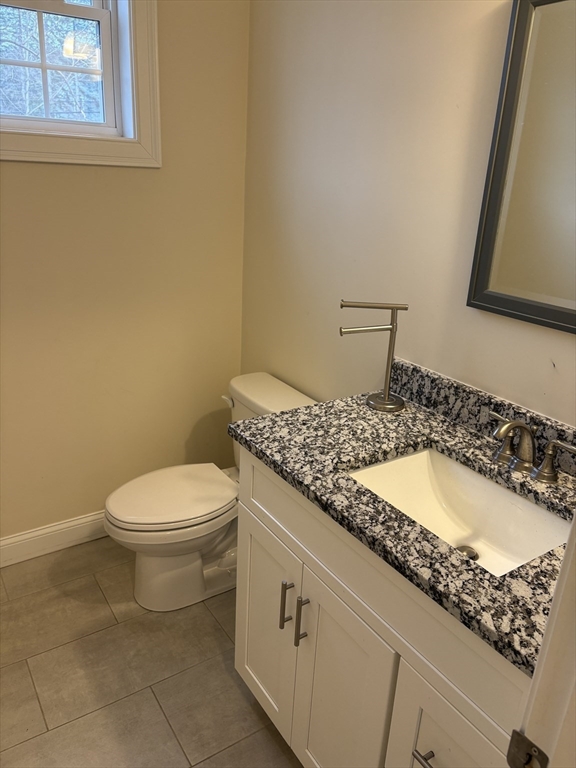 168 Main Street, Unit 1 Boylston, MA 01505 - Photo 10 of 24 a bathroom with a granite countertop toilet sink and mirror