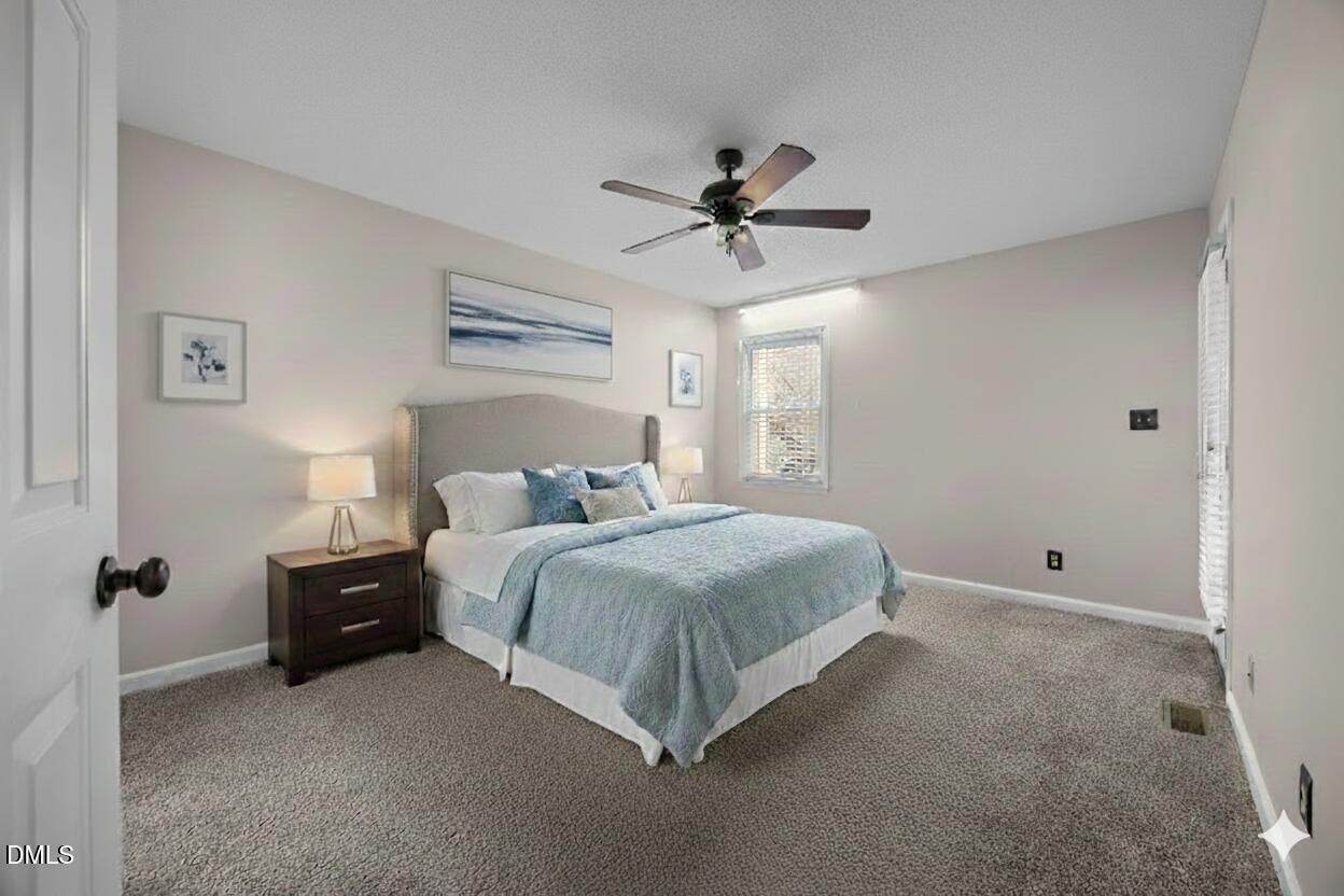 135 Boldleaf Court Cary, NC 27513 - Photo 13 of 34 a spacious bedroom with a bed and a chandelier