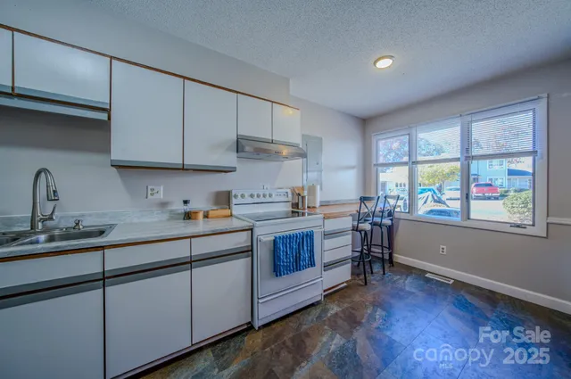 a kitchen with sink cabinets and window
