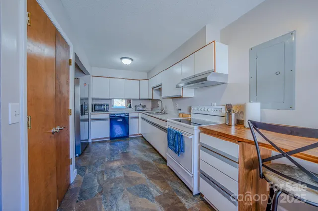 a large kitchen with stainless steel appliances granite countertop a lot of counter space and a sink