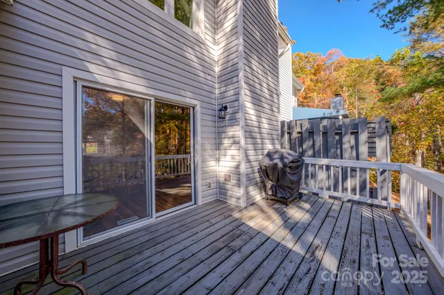 a view of a balcony with wooden floor and iron fence