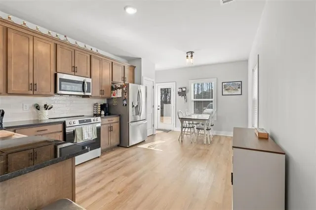 a kitchen with granite countertop cabinets stainless steel appliances and dining table