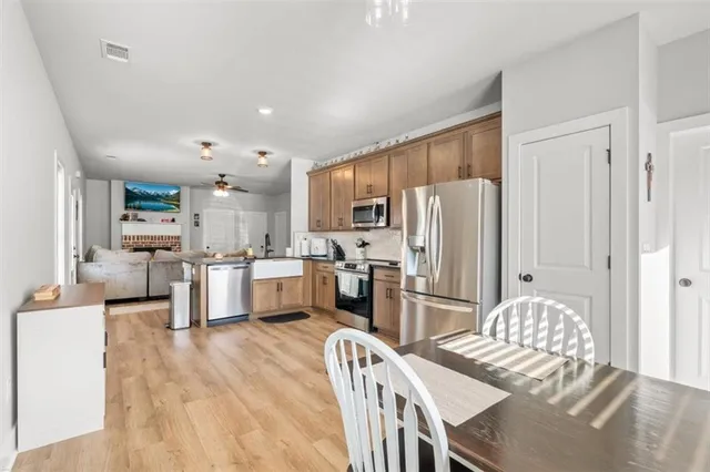 a kitchen with stainless steel appliances refrigerator wooden floor and furniture