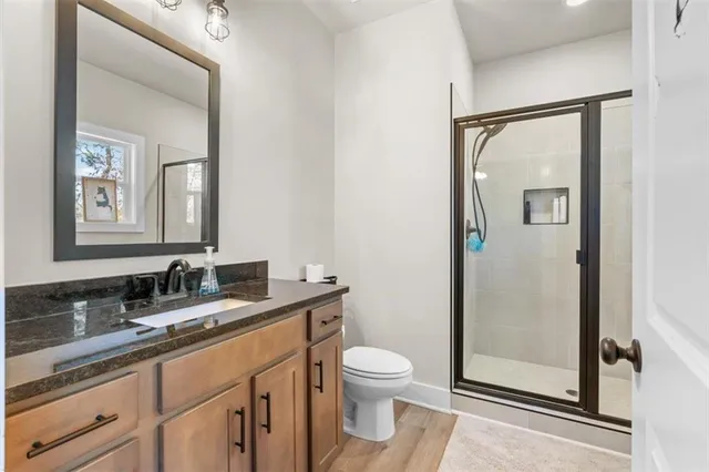 a bathroom with a granite countertop sink mirror vanity and toilet