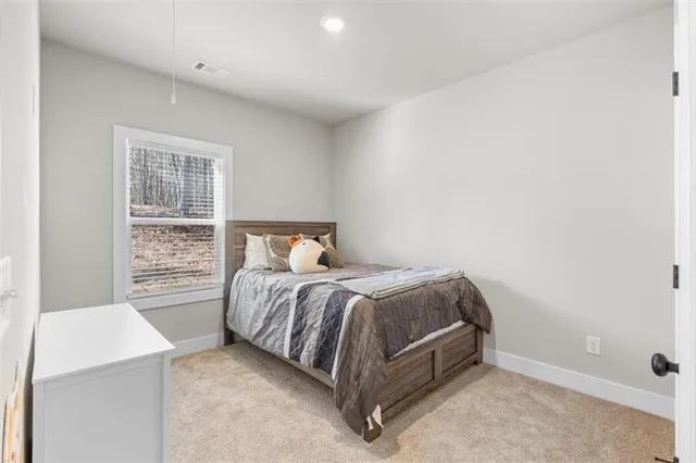 a bed sitting in a bedroom next to a window