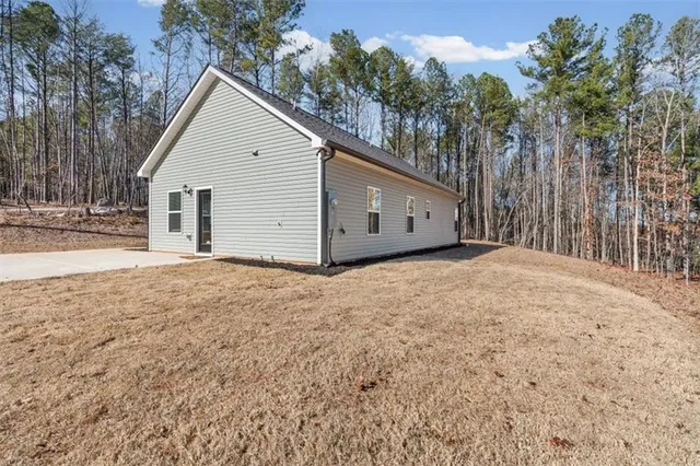 a view of wooden house with a yard and trees