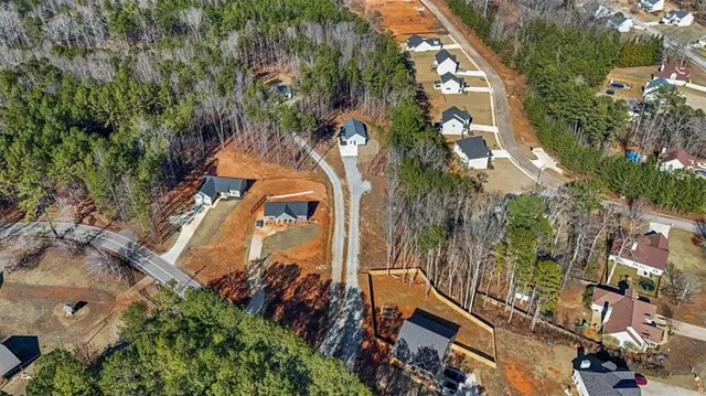 an aerial view of a house with a yard and large trees